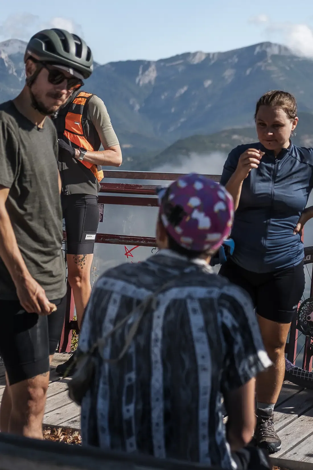 Groupe de cyclotouristes en pause à un point de vue, vélos appuyés à la rambarde